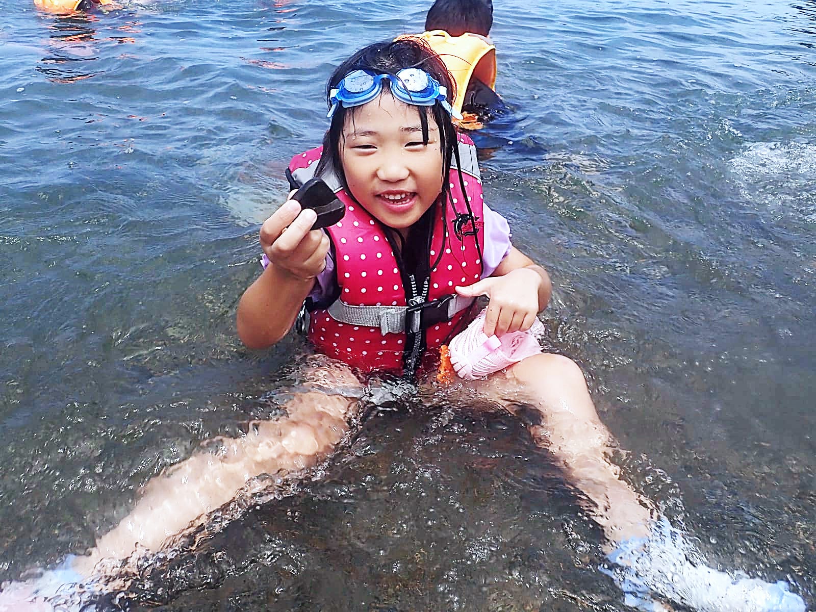 浅瀬にしゃがみ込んで石さがし