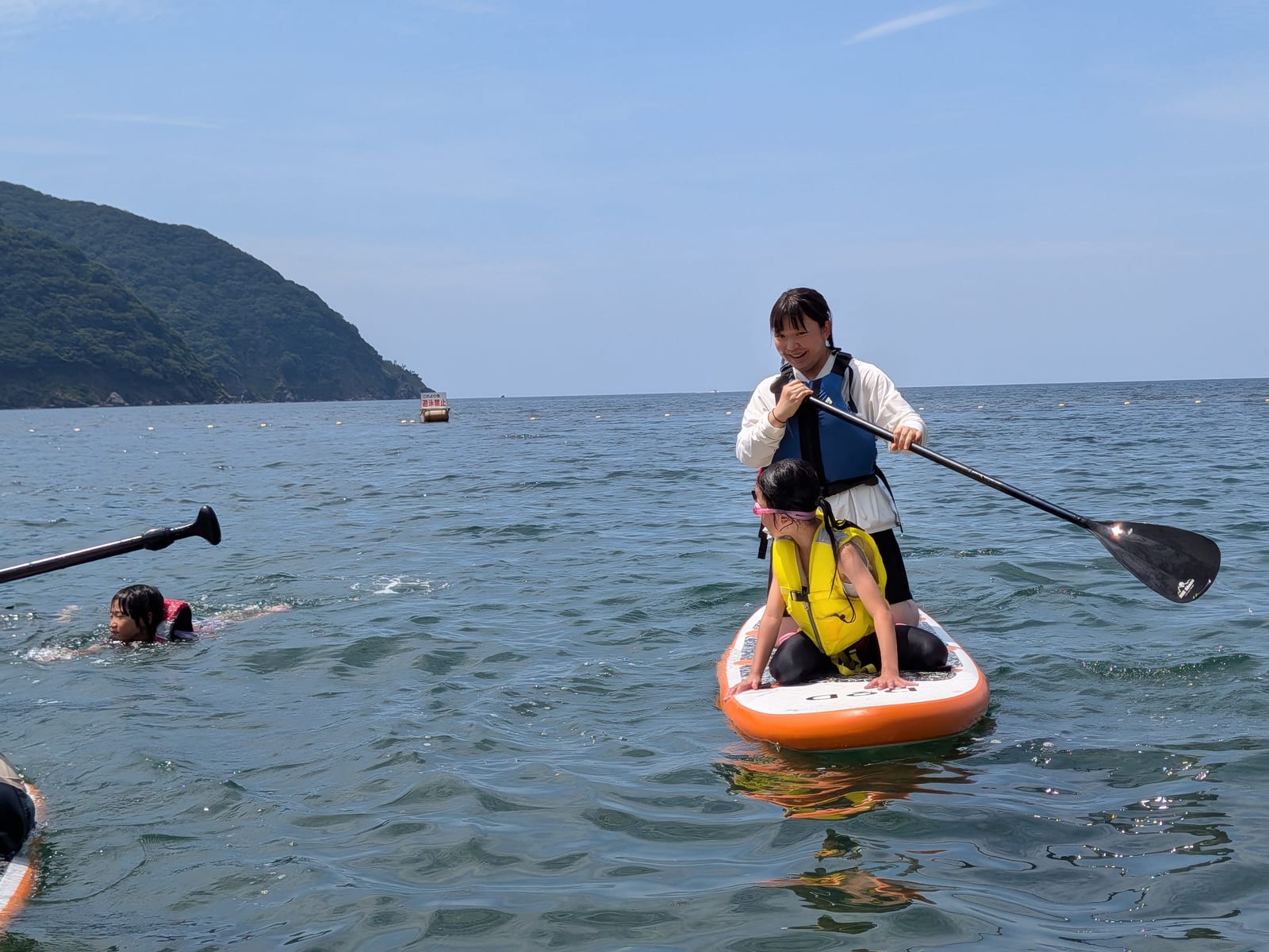 SUPの上に立ってパドルを漕ぐ